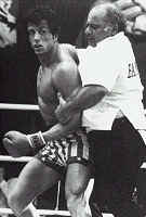 Paulie holds back Rocky from attacking Ivan Drago after the bell.